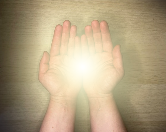 Katalin's hands emanating the bright light of Reiki.